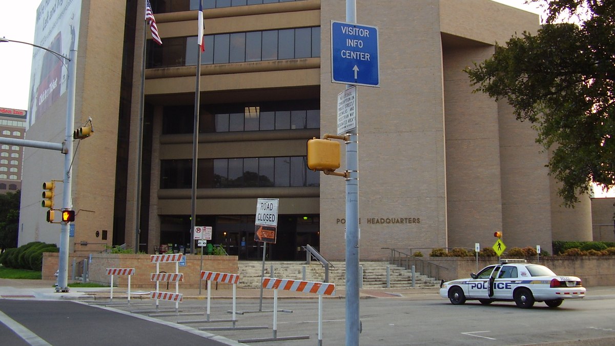 The Austin Police Department headquarters building with a police car parked out front