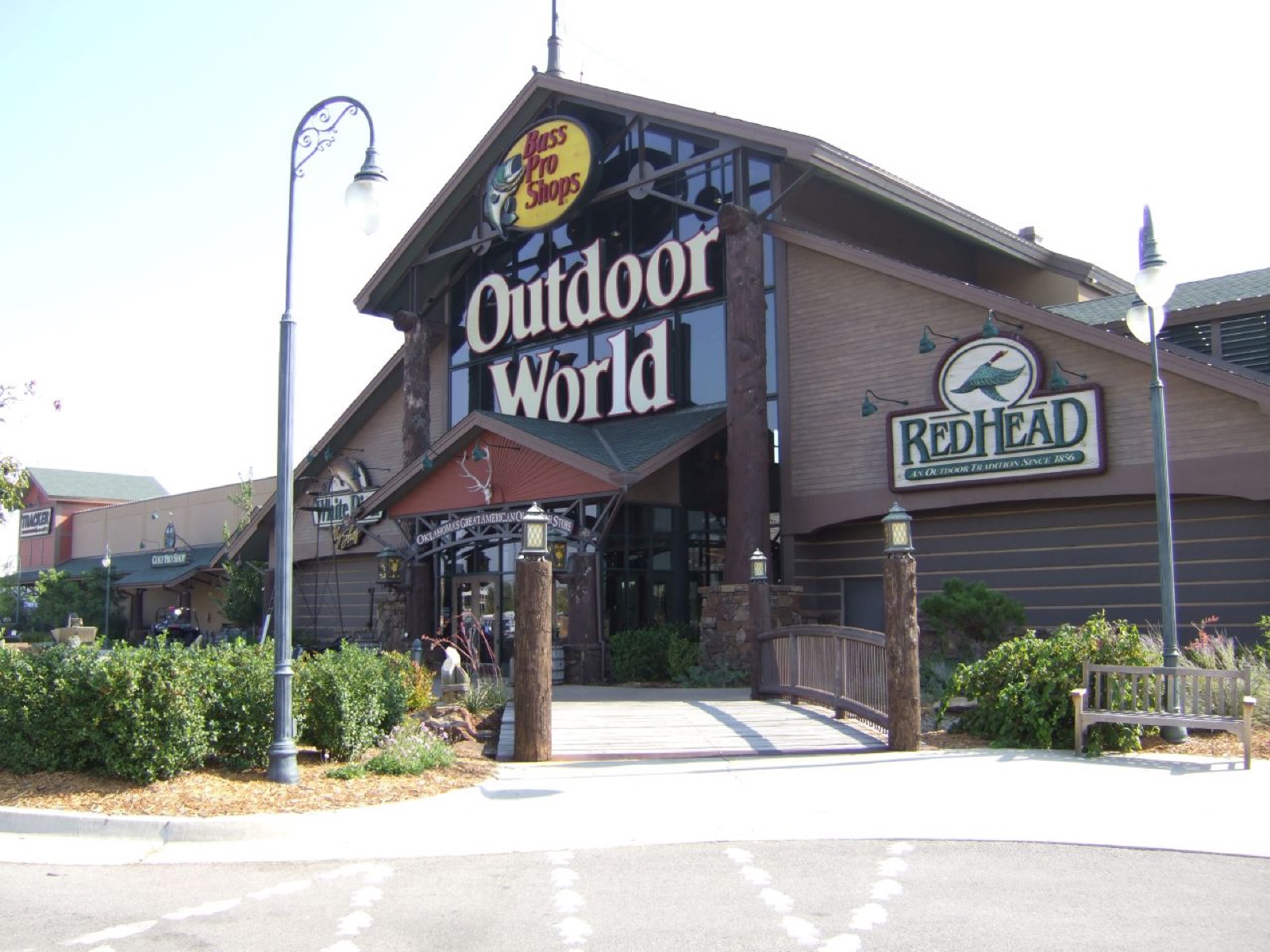 The front of the Bass Pro Shops Outdoor World store in Oklahoma City with a wooden footbridge leading to the entrance