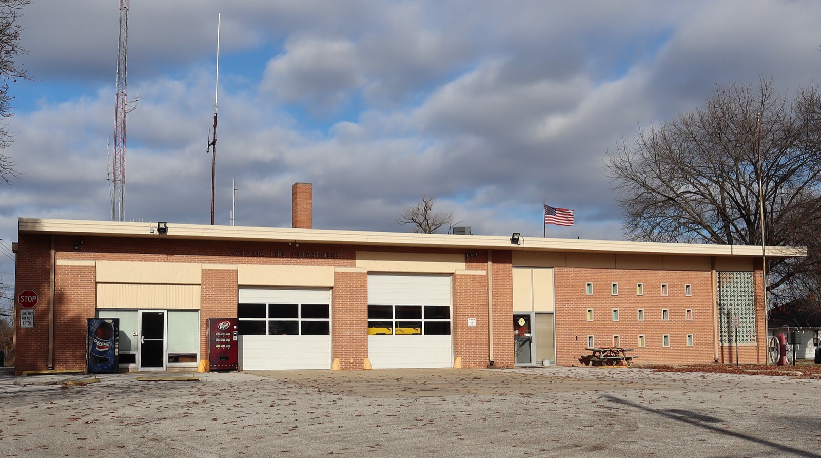 A one-story brick fire station with three garage doors under a cloudy sky in Cahokia, Illinois