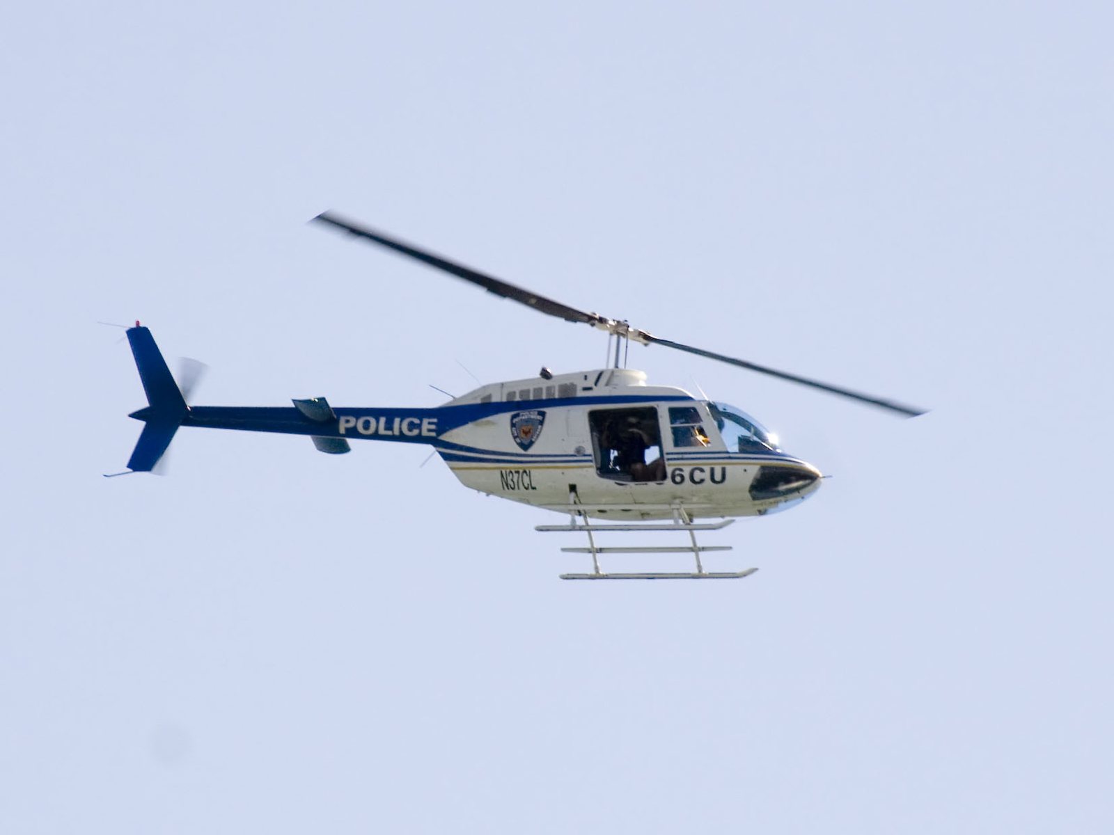 A white and blue Chicago Police Department helicopter in flight
