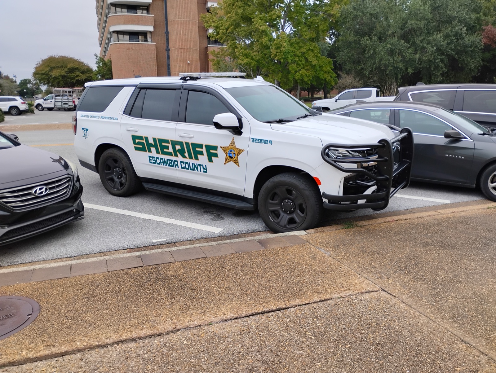 A white Escambia County Sheriff's Office Chevrolet Tahoe parked in a lot