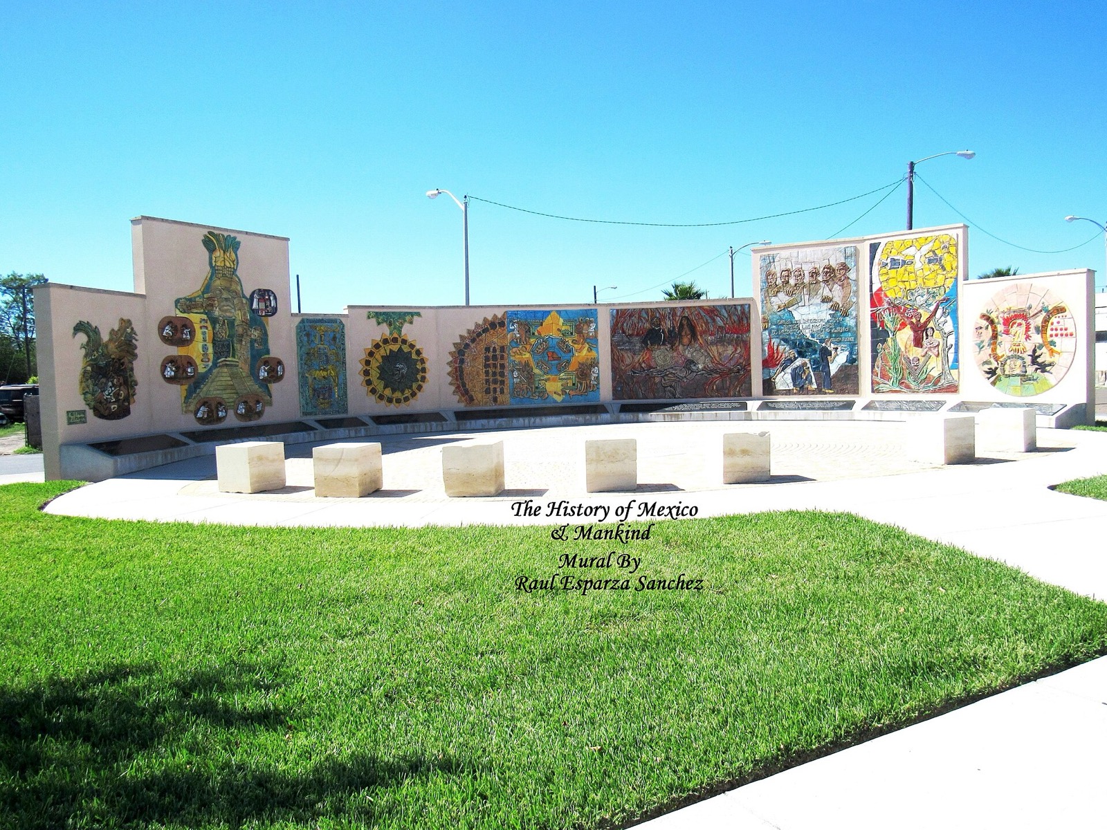 A row of colorful mosaic mural panels titled The History of Mexico and Mankind beside a lawn in Harlingen, Texas