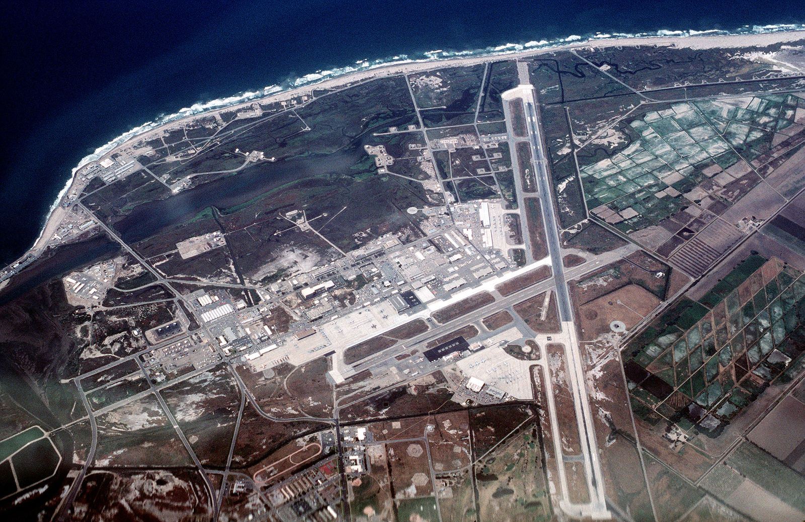 Aerial view of the Point Mugu naval air station on the California coast, with runways beside the ocean