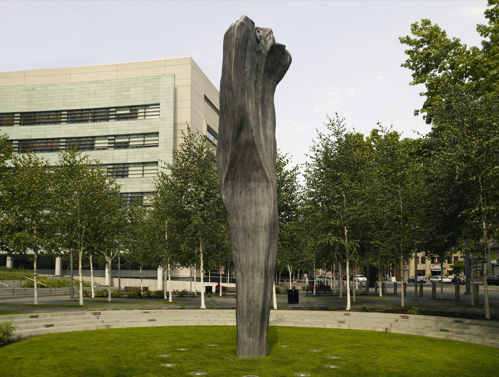 The U.S. Courthouse in Seattle behind the tall bronze sculpture Pillar Arc and a lawn